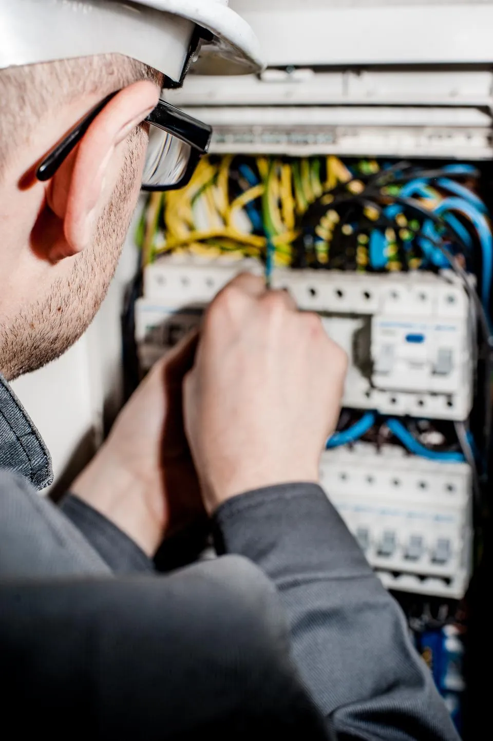 Elektrik panosunda kaçak akım rölesini kontrol eden teknisyen